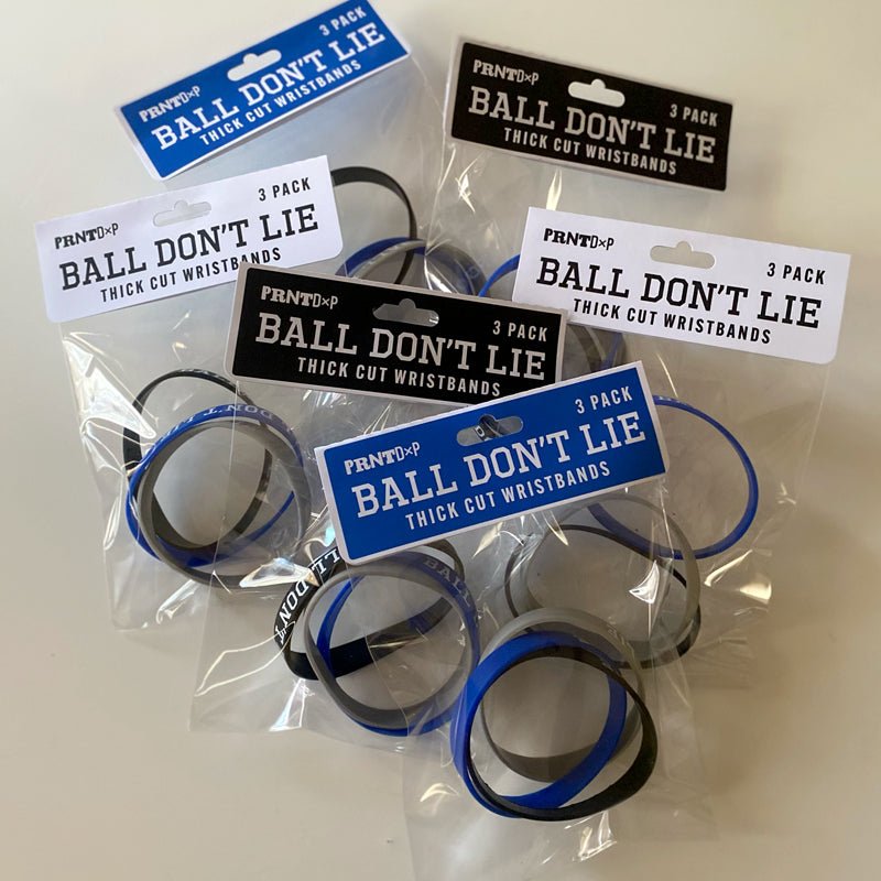 A tabletop shot of multiple packages of sillicone wristbands  with motivational type