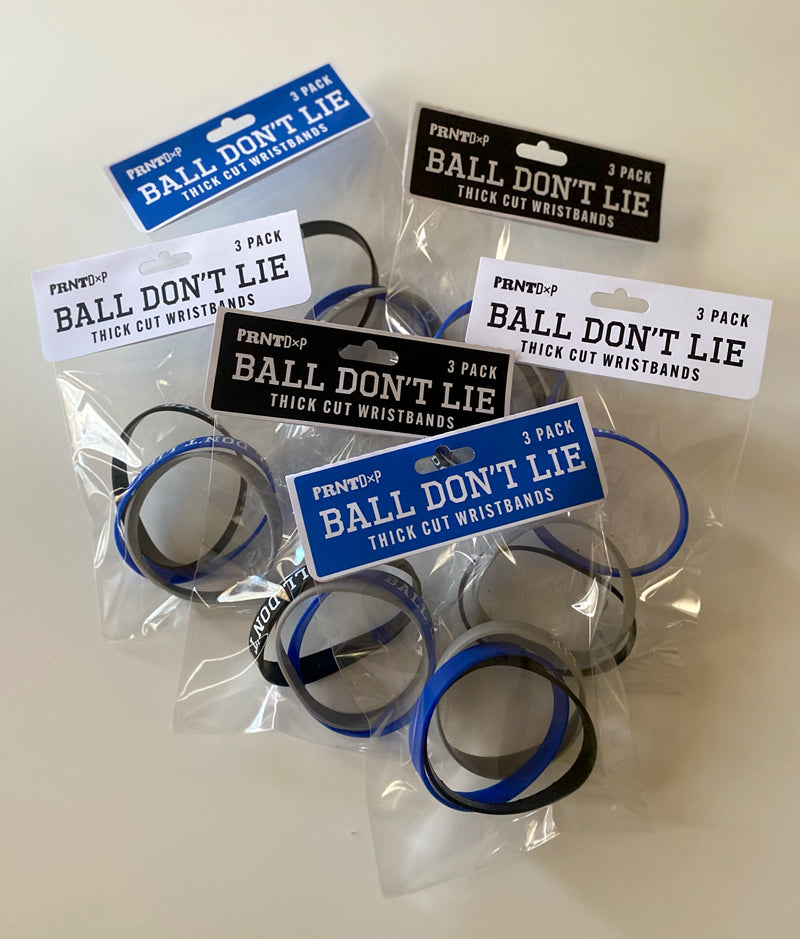 A tabletop shot of multiple packages of sillicone wristbands  with motivational type