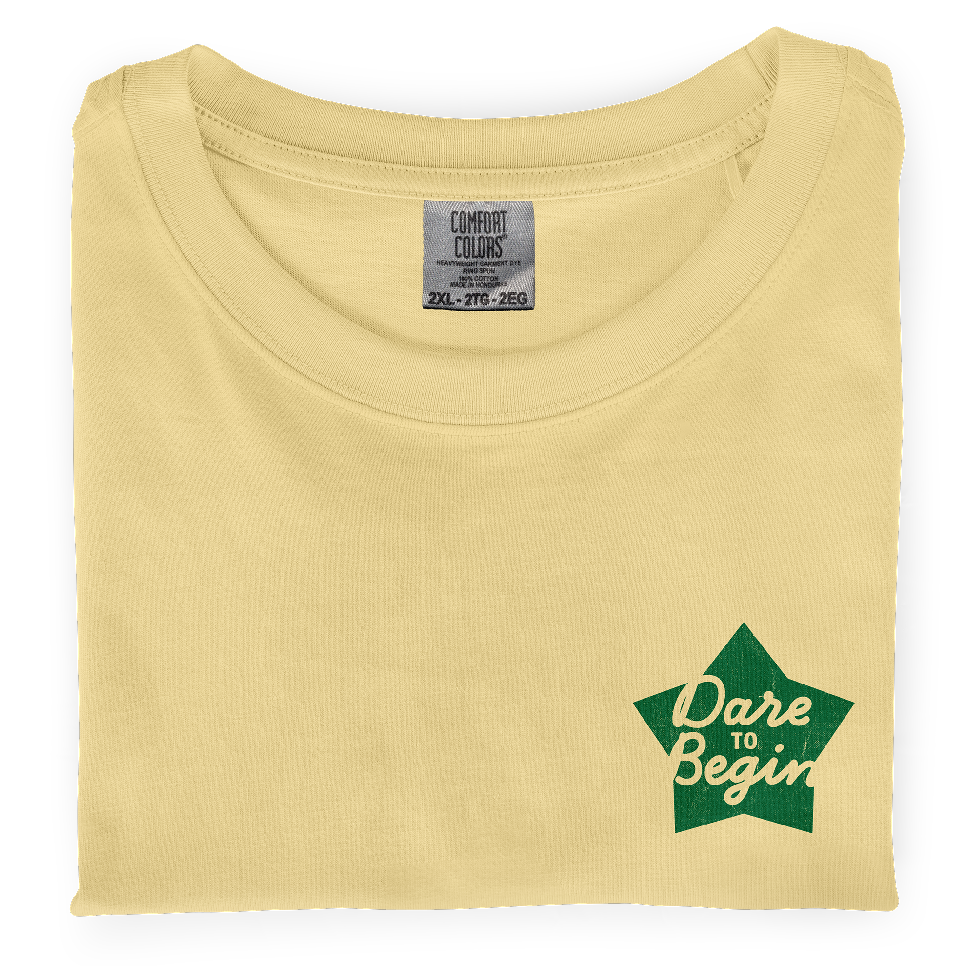 Picture of a folded, butter dyed-ink comfort colors t-shirt with  an screen printed  imprint on the chest that says Dare to Begin.